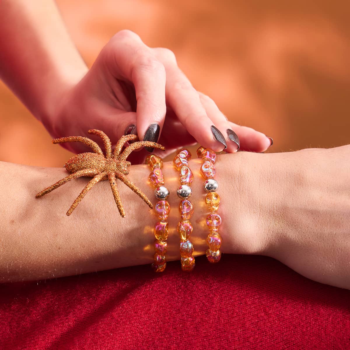 Ritual crystal skull bracelet with 10mm orange crystal skull beads and silver charm on stretch cord by NOGU